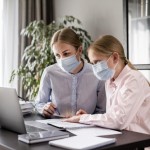 woman helping girl with homework while wearing medical mask 23 2148598019
