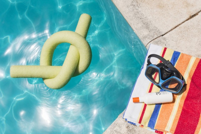 goggles with lotion towel near pool