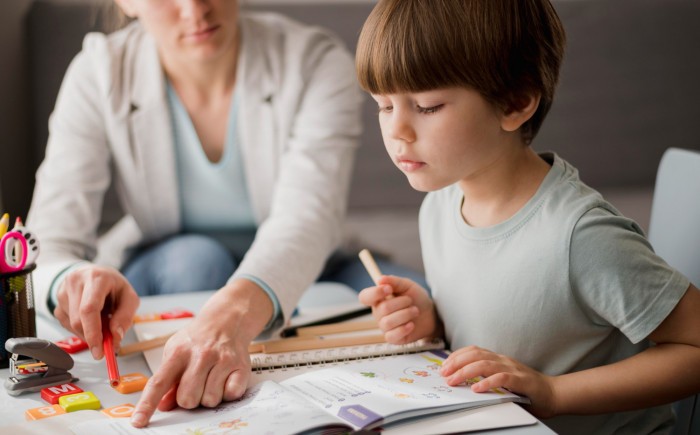 side view child learning from tutor home