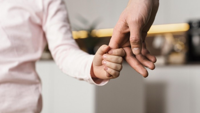 little girl holding hands with father